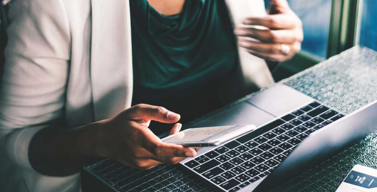 Woman holding a phone in front of a notebook